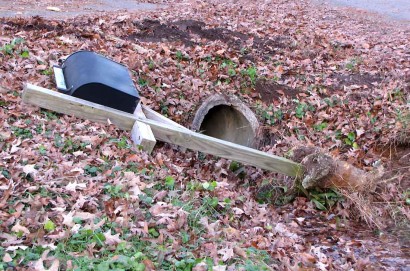 Tire tracks over top of culvert. Black rural mailbox on bank.