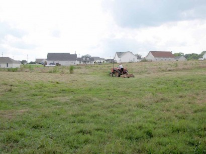 The Farmer mowing back pasture. Farmer on Allis Chalmers tractor.