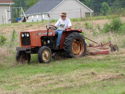 Mowing with Allis Chalmers 5020 tractor. farmer mowing field